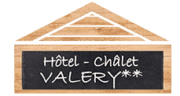 Enseigne noire rectangulaire avec texte blanc 'Hôtel - Châlet VALERY**' devant un fond boisé clair.